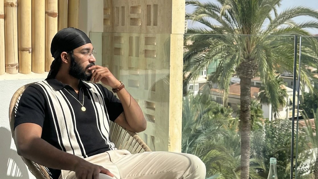 Jaidev Bhogal on a sunny hotel balcony overlooking palm trees
